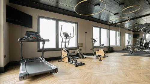 a gym with treadmills and exercise bikes in a room at Hotel Sentio in Vöhringen