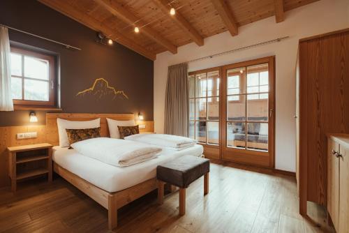 Un dormitorio con una cama grande y una ventana en Refugium LaFlu Apartments, en Corvara in Badia