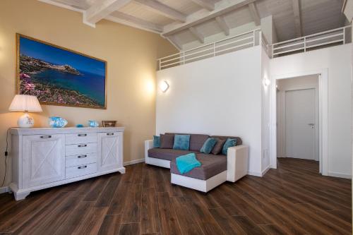 a bedroom with a bed and a couch and a dresser at La Chicca in Valledoria