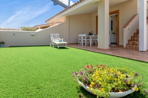 a backyard with a green lawn and a bowl of flowers at La Chicca in Valledoria