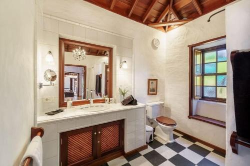 a bathroom with a sink and a toilet and a mirror at Finca Esperanza mit Privatpool, Whirlpool & Sauna in El Paso