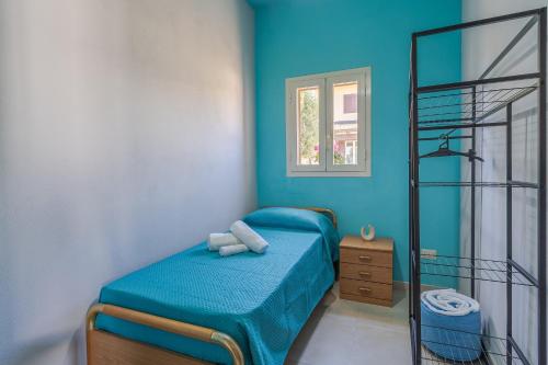a bedroom with a bed with a blue wall at Ape Ermy in Avola