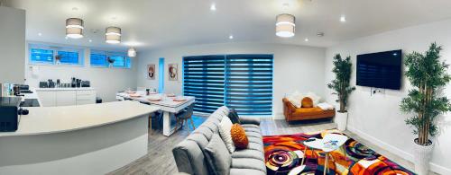 a living room with a couch and a kitchen at Luxury Town Centre House, Faversham in Faversham
