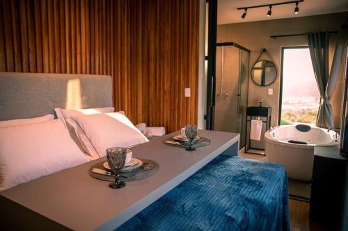 um quarto com uma cama grande com uma banheira e um estofado de esterco em Cabanas Sunset View em Urubici