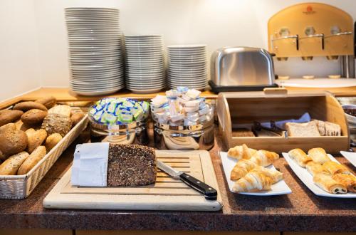 a table with many different types of bread and pastries at Garner Hotel Bremen North by IHG in Bremen