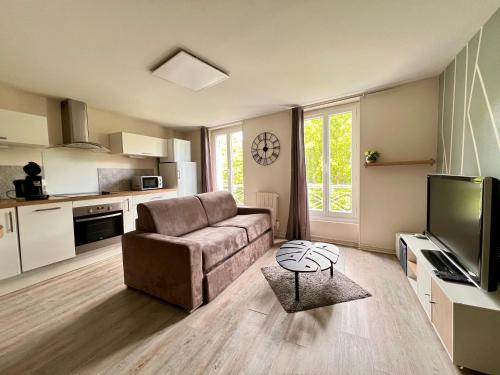ein Wohnzimmer mit einem Sofa und einem Tisch in der Unterkunft LE MONTAIGNE - Wifi fibre- Coeur du centre ville-PROPERTY RENTAL NM in Périgueux