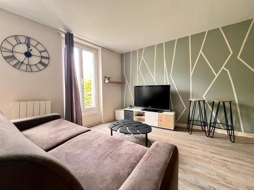 ein Wohnzimmer mit einem Sofa und einem TV in der Unterkunft LE MONTAIGNE - Wifi fibre- Coeur du centre ville-PROPERTY RENTAL NM in Périgueux