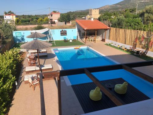 einen Pool mit Stühlen und einem Sonnenschirm neben einem Haus in der Unterkunft Villa Evenik in Eretria
