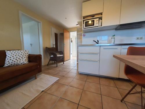 a kitchen with a couch and a table in a room at Haus Achtern Diek in erster Reihe am Meer in Fehmarn