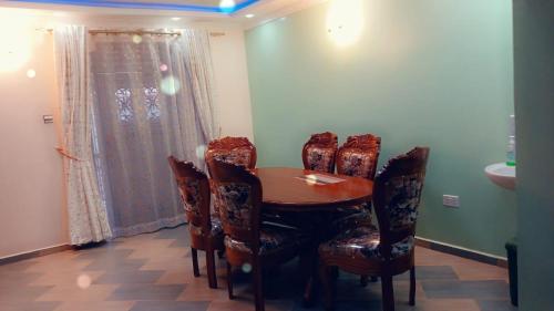 uma sala de jantar com uma mesa de madeira e cadeiras em Muringa Villa em Nyeri