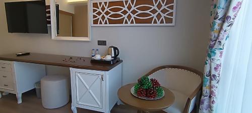 un escritorio y una mesa con un bol de fruta en una silla en Polaris Hayat Motel, en Büyükkeçeli
