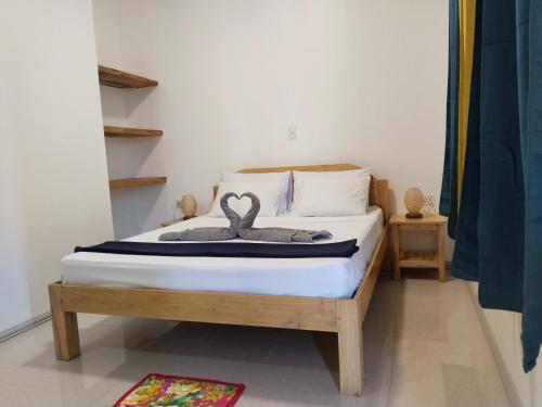 a bedroom with a bed with two swans on it at Sambag Hideaway Bungalows in Moalboal