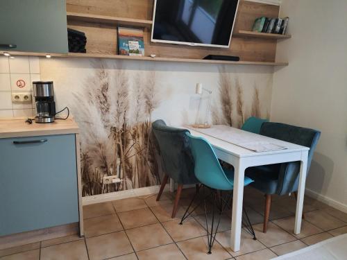 a kitchen with a white table and chairs at Haus Achtern Diek in erster Reihe am Meer in Fehmarn