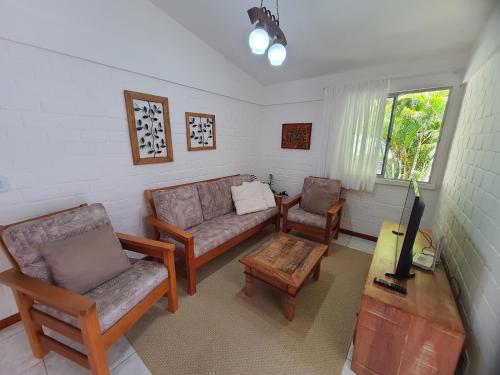 a living room with a couch and chairs and a table at Casa aconchegante com vista para as montanhas in Teresópolis
