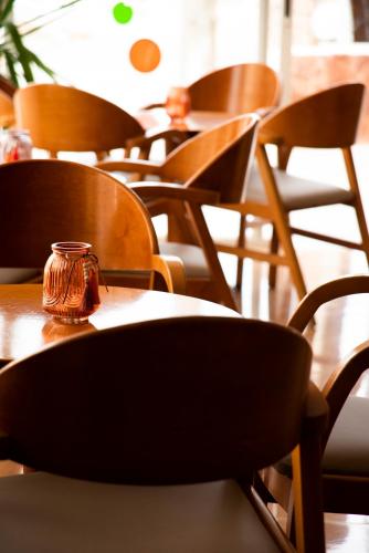 a row of tables and chairs with a jar on them at Hostal Mar y Huerta in Es Cana