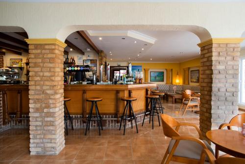 a bar in a restaurant with tables and chairs at Hostal Mar y Huerta in Es Cana