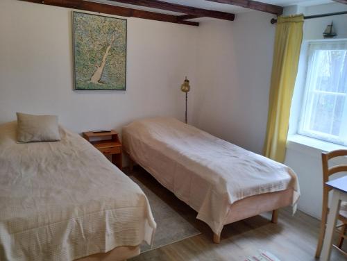 een slaapkamer met 2 bedden en een raam bij Saunallinen huone omakotitalossa - old wood house - in Turku