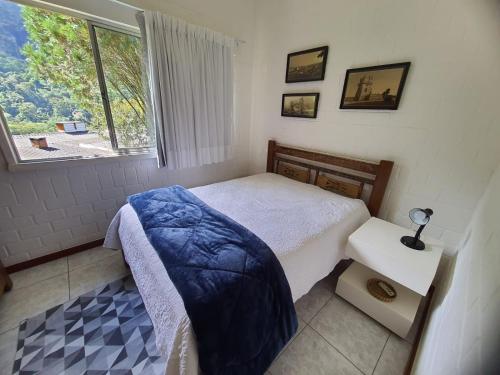 a small bedroom with a bed and a window at Casa aconchegante com vista para as montanhas in Teresópolis