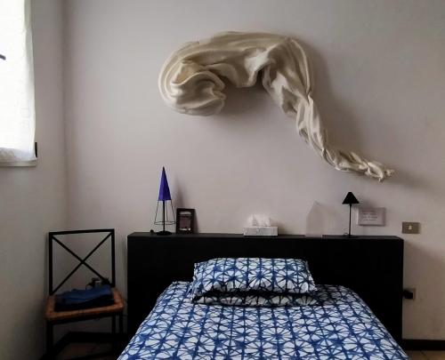 ein Schlafzimmer mit einem Bett und einer Decke an der Wand in der Unterkunft la melagrana rossa in Quattro Castella