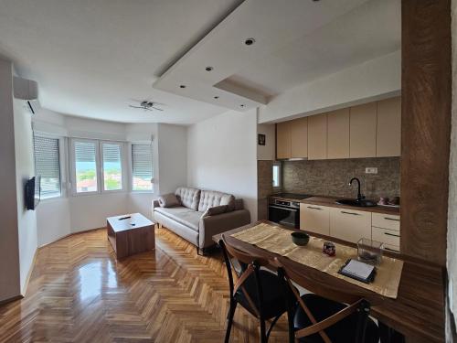 une cuisine et un salon avec une table et un canapé dans l'établissement Sunčani apartman, à Nikšić