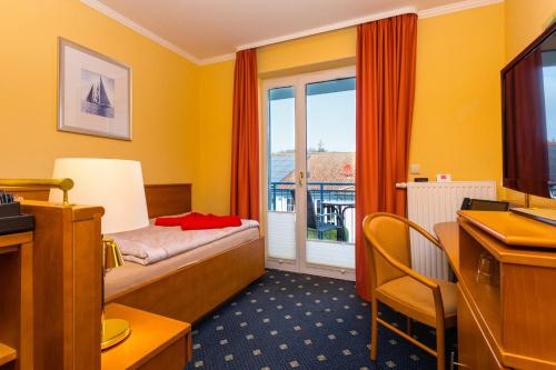 una camera d'albergo con letto e finestra di Hotel & Restaurant Hanse Kogge a Ostseebad Koserow