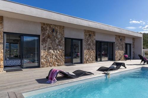 une femme se posant au bord d'une piscine dans l'établissement Villa Albizia 6P, private heated pool sea view 5 minutes from Favone Beach, à Conca