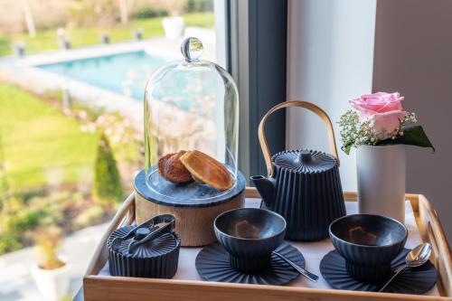 a tray with bread and cups on a table with a window at Hotel Dali Val d'Europe, Tapestry Collection by Hilton in Chanteloup-en-Brie