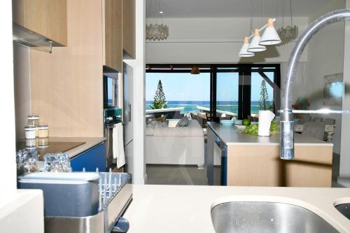 a kitchen with a sink and a view of the ocean at Penthouse de la plage, private lift in Belle Mare