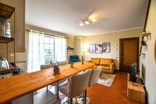 een woonkamer met een grote houten tafel en stoelen bij Angolo Paradiso - Casa vacanze sui campi da golf in Fubine