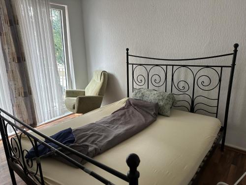 a bed in a bedroom with a chair and a window at Monteuren Wohnung in Hannover