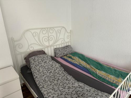 Dormitorio pequeño con cama con cabecero blanco en Monteuren Wohnung, en Hannover
