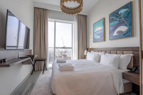 ein Schlafzimmer mit einem großen weißen Bett und einem großen Fenster in der Unterkunft Avani Plus Palm View Dubai Suites in Dubai