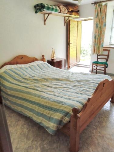 a bedroom with a bed with a striped comforter at Chalet de 3 chambres avec jardin amenage a Beaufort a 8 km des pistes in Beaufort