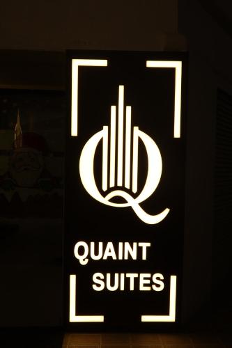 un cartello per le suite aqualitt in una stanza buia di Quaint Suites Hotel & Banquet a Mumbai