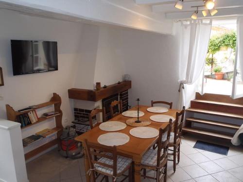 une salle à manger avec une table, des chaises et une télévision dans l'établissement Fisherman`s Cottage, à Mortagne-sur-Gironde