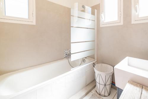 een badkamer met een wit bad en een wastafel bij domaine los reyes in Saint-Cyprien