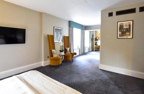 a hotel room with a bed and a flat screen tv at The Rutland Hotel & Apartments in Edinburgh