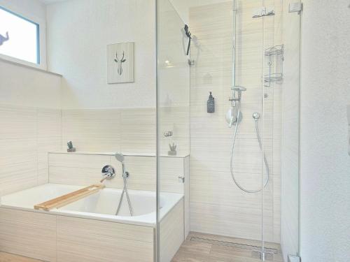 La salle de bains est pourvue d'une baignoire et d'une douche. dans l'établissement Black Forest I Sauna I Boxspring I Nespresso I Wasserfälle I Bergblick, à Todtnau