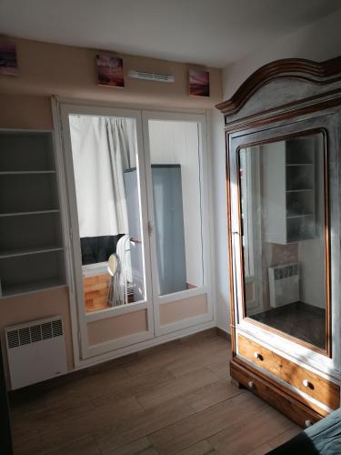 Cette chambre dispose de 2 grandes fenêtres et d'un miroir. dans l'établissement Appartement 35m2-les marinas-30m de la plage, à Courseulles-sur-Mer