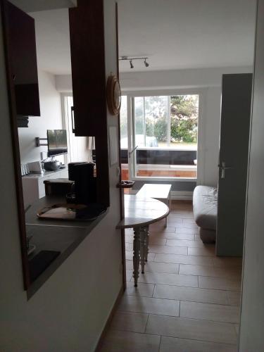 - une cuisine avec une table et un bureau dans la chambre dans l'établissement Appartement 35m2-les marinas-30m de la plage, à Courseulles-sur-Mer