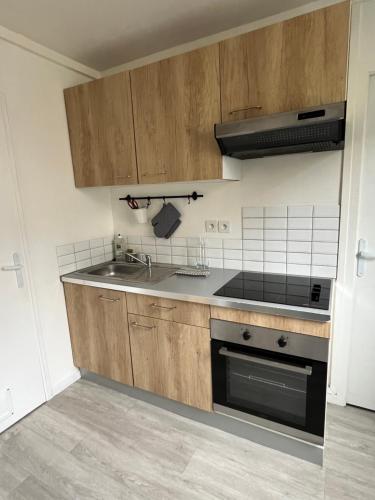 une cuisine avec un évier et une cuisinière dans l'établissement Vivez l'Atlas-Proche de la plage, au Havre