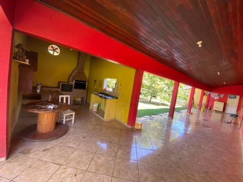ein Wohnzimmer mit einer roten Decke und einem Tisch in der Unterkunft Chácara Manjedoura in Ji-Paraná