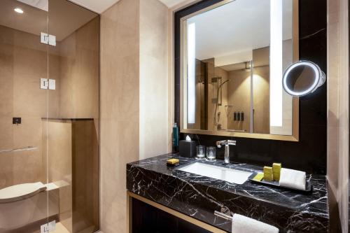 a bathroom with a sink and a mirror and a shower at Hilton Riyadh Olaya in Riyadh