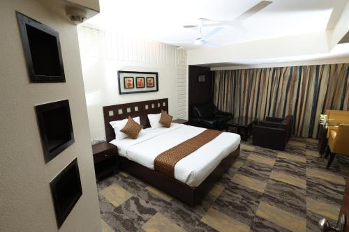 a bedroom with a bed and a living room at Quaint Suites Hotel & Banquet in Mumbai