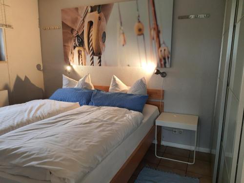a bedroom with a bed with blue and white pillows at Haus Achtern Diek in erster Reihe am Meer in Fehmarn