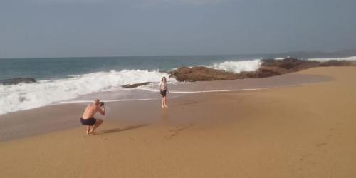 two women standing on the beach near the ocean at Sea Face Rest Hambantota in Hambantota