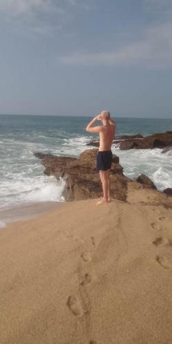 a man standing on the beach looking at the ocean at Sea Face Rest Hambantota in Hambantota