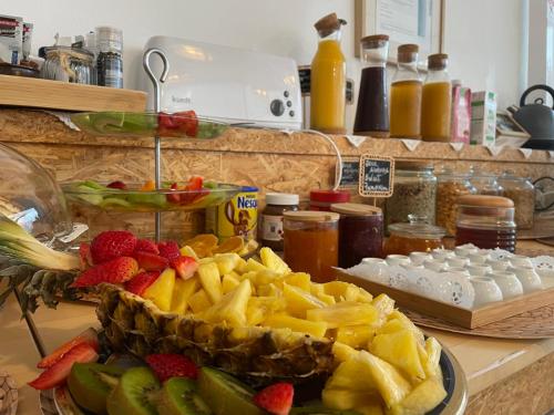 Calmaria Guesthouse في بورتو كوفو: طاولة مقدمة مع صحن من الفواكه على منضدة
