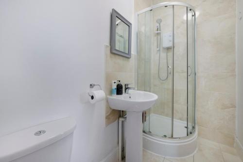 a white bathroom with a shower and a sink at Archway Station Studios - Double bed in London