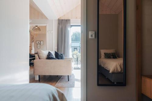 a bedroom with a mirror and a bed and a chair at Knus I Tiny house op de Veluwe in Epe